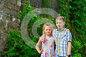 Brother and sister stand in an embrace in the park on the street and look at each other. The concept of happiness, family, love,