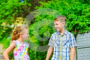 Brother and sister stand in an embrace in the park on the street and look at each other. The concept of happiness, family, love,