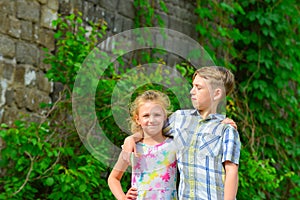 Brother and sister stand in an embrace in the park on the street and look at each other. The concept of happiness, family, love,