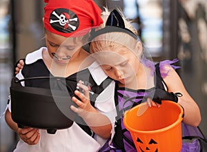Childhood disappointments. A brother and sister sulk together and look at their empty sweet baskets on halloween. photo