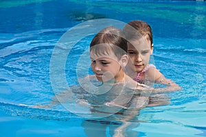 Brother sister swim play in pool