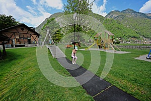 Brother with sister swinging in playground at Hallstatt, Austria