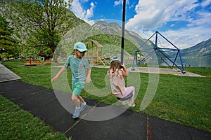 Brother with sister swinging in playground at Hallstatt, Austria