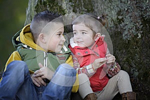 Brother and sister talking to each other outdoors