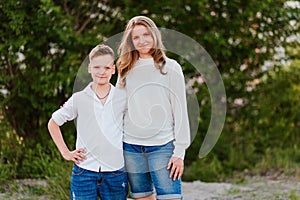 Brother and sister teens in white shirts cuddle