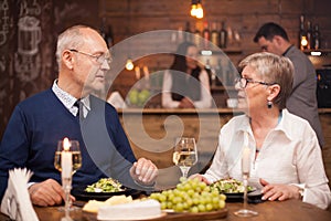 Brother and sister in their sixties enjoying their time together while dining in a vintage restaurant