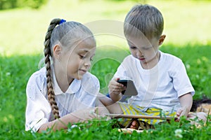 Brother and sister using a smartphone and tablet PC