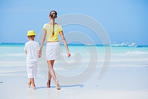 Brother and sister walking on the beach during the hot summer vacation day.