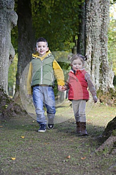 Brother and sister walking in the woods