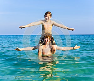 Brothers are enjoying the clear warm water in the ocean and play