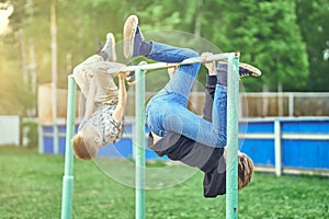 Brothers hanging and playing on bars in schoolyard