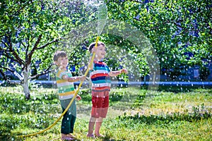 Brothers having fun splash each other with water in the village