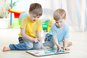 Brothers kids reading book together at home