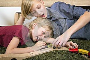 Brothers play with wooden train, build toy railroad at home or d