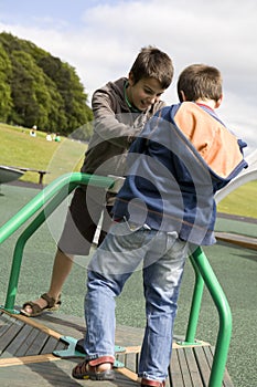 brothers on playground, climbing a roped frame photo