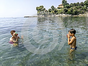 Brothers playing on a beach in the mediterranean sea with a ball