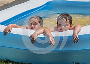 Brothers pose in an inflatable swimming pool