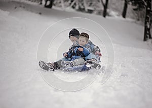 Brothers sledging down the hill