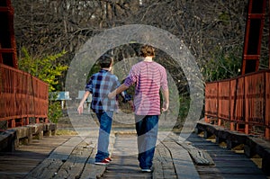 Brothers walking on a bridge.