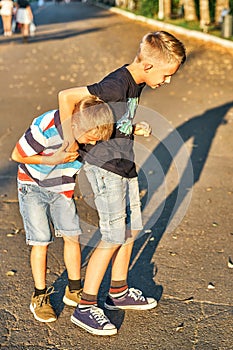 Brothers wrestle on sidewalk in public park