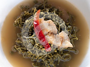 Broussonetia Kurzii spicy soup with pork in white bowl background