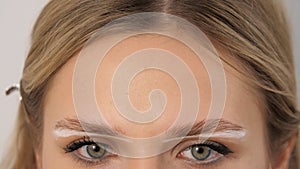 Brow paste on beautiful eyes. Attractive female face of a blonde well-groomed woman or lady.