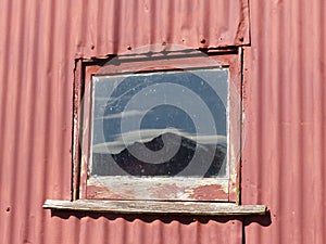 Brow Peak mountain reflected in barn window