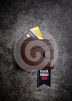 Browen leather wallet with text Black Friday Sale on a tag and credit cards top view flat lay on dark background