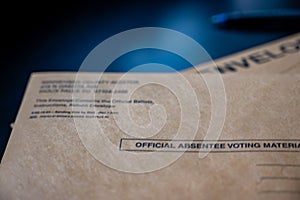 Brown absentee ballot return envelope with blank signature line on a desk with a pen