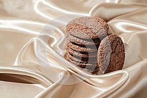 Brown american cookies on beige silk background. Minimal style. Bakery and pastry concept