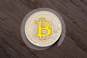 Brown background with golden bitcoin on it.
