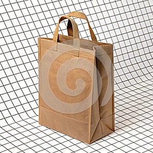 Brown bag with handle isolated on a grid background