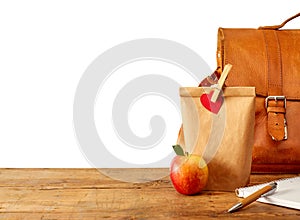 Brown bag lunch and notebook on table