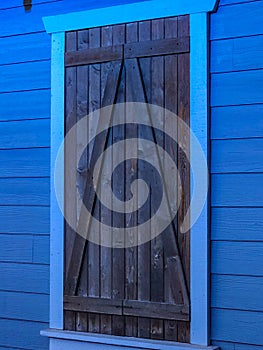 Brown barn window on blue building