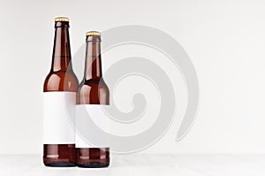 Brown beer bottles longneck 500ml and 330ml with blank white label on white wooden board, mock up.