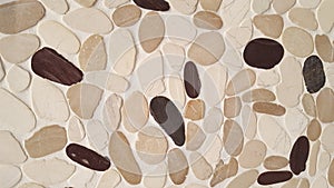 Brown beige black stone wall of pebbles background texture