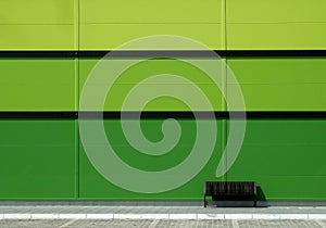 Brown bench in front of green wall