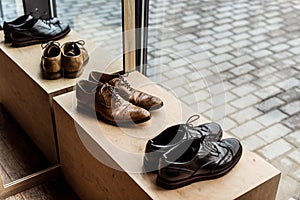 Brown and black male shoes at showcase in shop