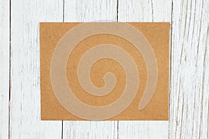 Brown blank greeting card on weathered whitewash textured wood background