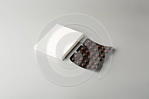 Brown blister packs with pills and white box