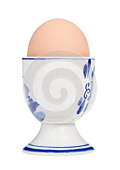 brown boiled egg in cup with a blunt end up