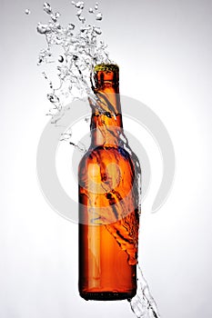 Brown bottle of beer and a water splash