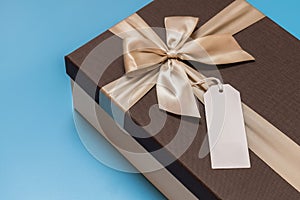 Brown box with golden ribbon and a blank label attached