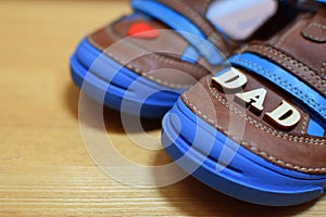 Brown boy`s shoes with blue soles and little red heart and word dad