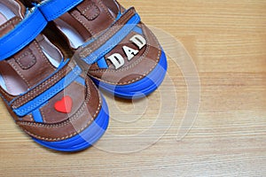 Brown boy`s shoes with blue soles and little red heart and word dad