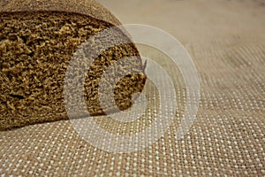 Brown bread on bagging fabric. Closeup view of whole wheat rye bread sliced loaf of fresh homemade bakery. Healthy food and carbs