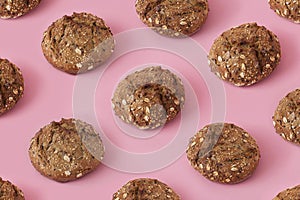 Brown bread buns with seeds on pink background