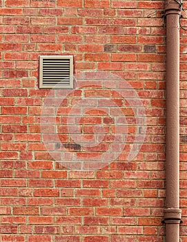 Brown Brick Wall with Vent and Old Pipe