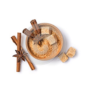 Brown cane granulated and cubes sugar in wooden bowl with spices