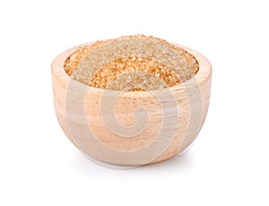 Brown cane sugar in wooden bowl on white background